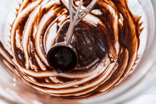 Baking chocolate cupcakes. Scooping chocolate cupcake batter into a cupcake pan.