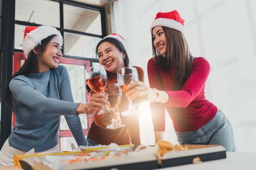 Friends at birthday party clinking glasses with champagne and pizza, enjoying Christmas vacation, pizza on the table. Holiday Party event.