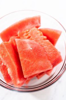 Cutting riped red watermelon to prepare frozen watermelon margarita.