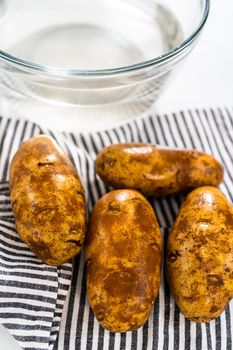 Pressure Cooker Baked Potatoes. Drying washed raw potatoes with a kitchen towel.