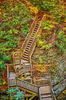 Image of Boardwalk staircase leads up through cliffs with fall leaves and foliage around