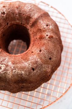 Cooling freshly baked red velvet bundt cake on a kitchen counter.