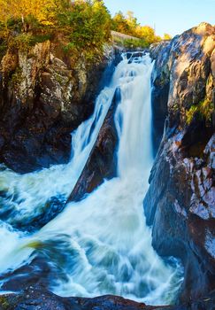 Image of Panoramic up close view of huge waterfall pouring angry through deep stone canyon gorge in fall