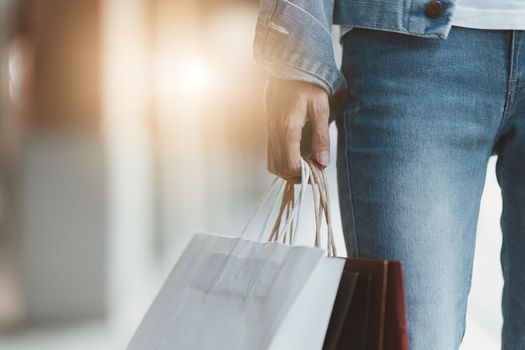 Asian fashionable woman walking at shopping mall with shopping bags while flash sale promotion.