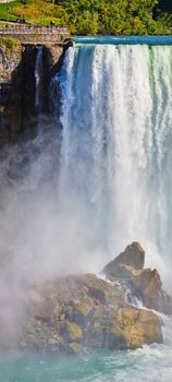 Image of Vertical panorama of American Falls from Canada showcasing size compared to tourists on overlook in Niagara Falls