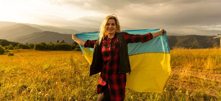 a woman with a flag of Ukraine. Ukraine waving flag in the sky
