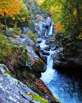 Image of Fall foliage surrounds waterfalls through gorge in stunning fall forest of New York