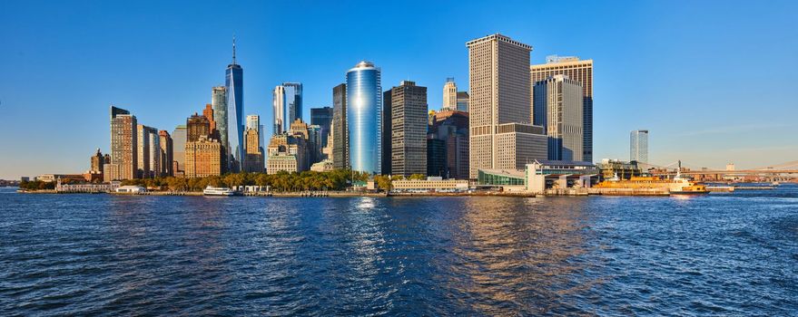 Image of Panoramic view of southern Manhattan New York City skyline approaching sunset over waters