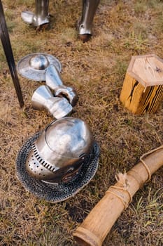 Knight's helmet, sword and battle horn on the ground.