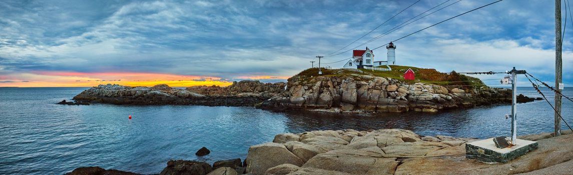 Image of Stunning Maine lighthouse on coast with dawn light panorama showing zipline trolley cart to get to island