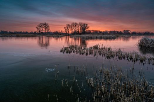 A colorful sunset over a frozen lake in eastern Poland