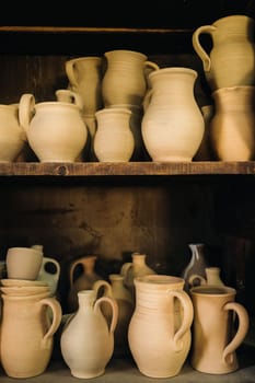 Ceramic clay jugs standing on a shelf in the village.