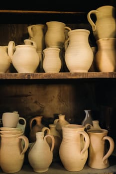 Ceramic clay jugs standing on a shelf in the village.