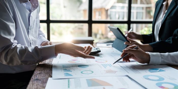 Asian business colleagues meeting to analyze financial reporting situation Investment and accounting concept sitting table and pointing at document. Profit chart. Graph showing growth.