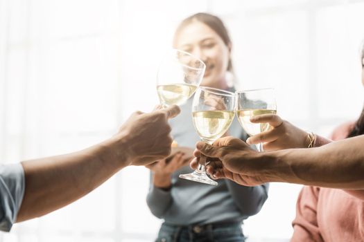 Group of happy colleagues having fun at a new year celebration or business success. Coworkers with diverse people at the office party.