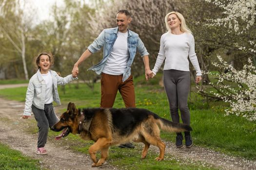 Mother, father and child daughter having fun outdoors.