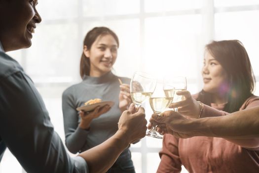 Group of happy colleagues having fun at a new year celebration or business success. Coworkers with diverse people at the office party.