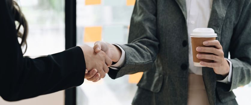 Welcome to our team. close up young modern women shaking hands while working in the creative office.