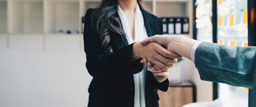 Welcome to our team. close up young modern women shaking hands while working in the creative office.