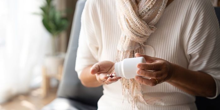 Close up mature woman taking out pills from bottle, supplements or antibiotic, older female preparing to take emergency medicine, chronic disease, healthcare and treatment concept.