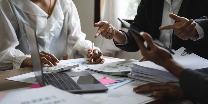 diverse coworkers working together in boardroom, brainstorming, discussing and analyzing and planning business strategy