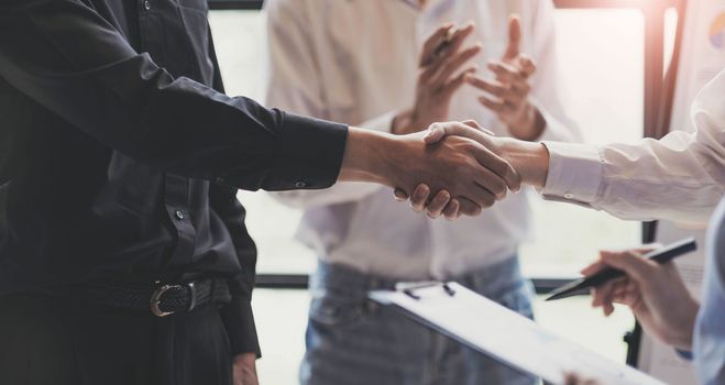 Business handshake for teamwork of business merger and acquisition,successful negotiate,hand shake,two businessman shake hand with partner to celebration partnership and business deal concept.