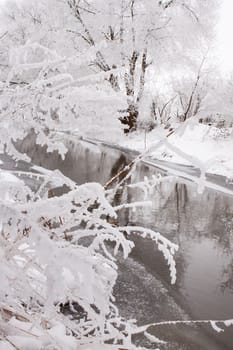 Snow-covered landscape of open spaces near the river. Snowy weather.