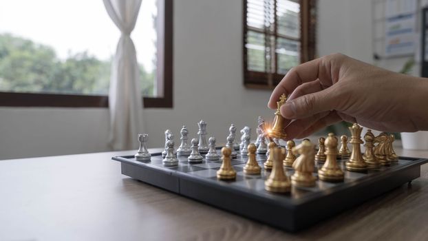 Closeup hand of man moving chess figure in competition success play. strategy, management or leadership concept.