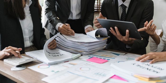 diverse coworkers working together in boardroom, brainstorming, discussing and analyzing and planning business strategy