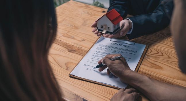 Discussion with a real estate agent, House model with agent and customer discussing for the contract to buy, get insurance or loan real estate or property..