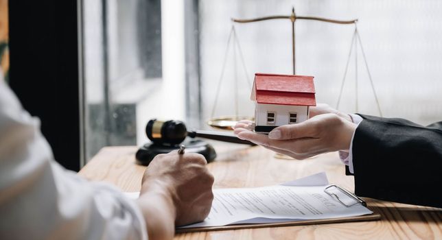 Real estate agent talked about the terms of the home purchase agreement and asked the customer to sign the documents to make the contract legally, Home sales and home insurance concept..