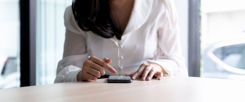 Closeup image of a businesswoman holding and using mobile phone