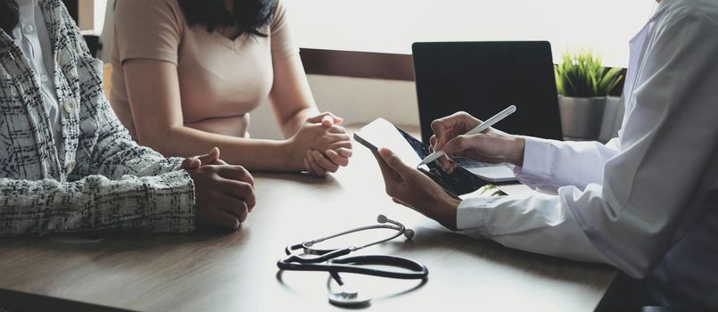 Doctor or physician writing diagnosis and giving a medical prescription to female Patient.