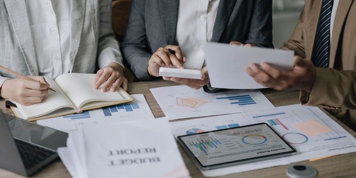 Asian business adviser meeting to analyze and discuss the situation on the financial report in the meeting room.Investment Consultant, Financial advisor and accounting concept.