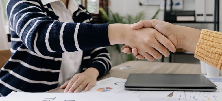 business people handshake at meeting table in office together. Young businessman and businesswoman workers express