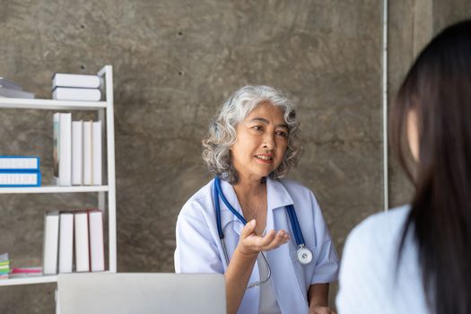 Doctor discussing with senior patient at table.