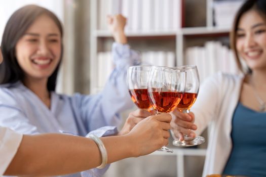 Group of Asian friends gather to celebrate Christmas with champagne and eating pizza at home. Joy of holiday party with friends or colleague concept.