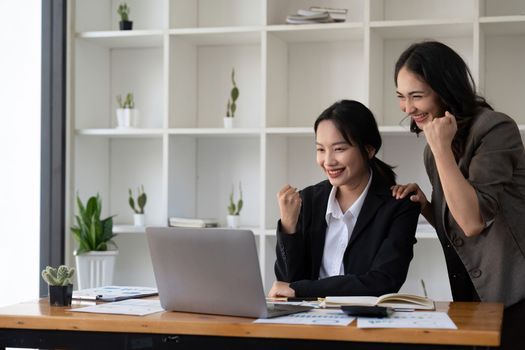 Group of Young Asian business team creative businesspeople coworker in office Happy to be successful partnership teamwork celebrating achievement and success concept.