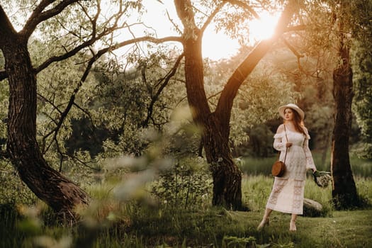 Portrait of a beautiful woman in a white dress and a hat with lilies of the valley at sunset. A girl in nature. Spring flowers.