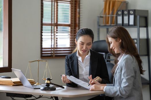Female lawyer discuss to a legal document explaining the terms of a consultation with a businesswoman. before signing a contract with a law firm