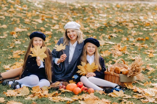 A big family on a picnic in the fall in a nature park. Happy people in the autumn park.