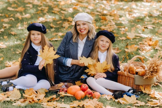 A big family on a picnic in the fall in a nature park. Happy people in the autumn park.