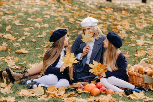 A big family on a picnic in the fall in a nature park. Happy people in the autumn park.