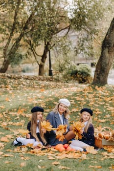 A big family on a picnic in the fall in a nature park. Happy people in the autumn park.