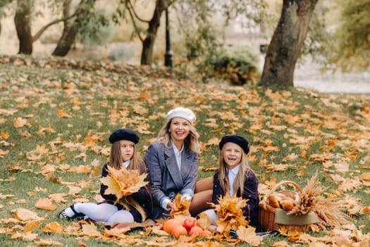 A big family on a picnic in the fall in a nature park. Happy people in the autumn park.