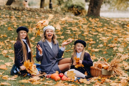 A big family on a picnic in the fall in a nature park. Happy people in the autumn park.