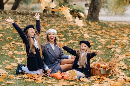 A big family on a picnic in the fall in a nature park. Happy people in the autumn park.