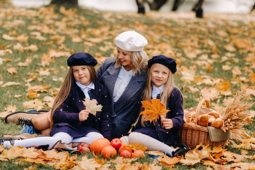 A big family on a picnic in the fall in a nature park. Happy people in the autumn park.