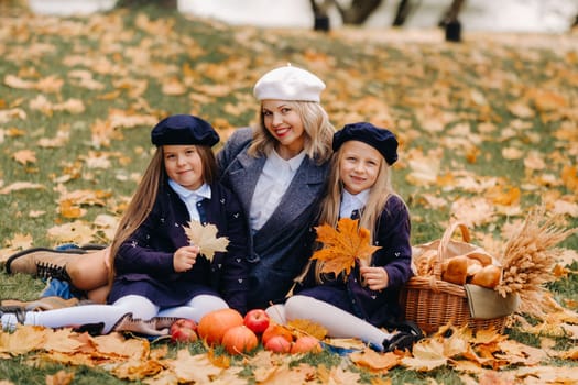 A big family on a picnic in the fall in a nature park. Happy people in the autumn park.