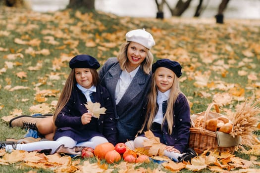 A big family on a picnic in the fall in a nature park. Happy people in the autumn park.